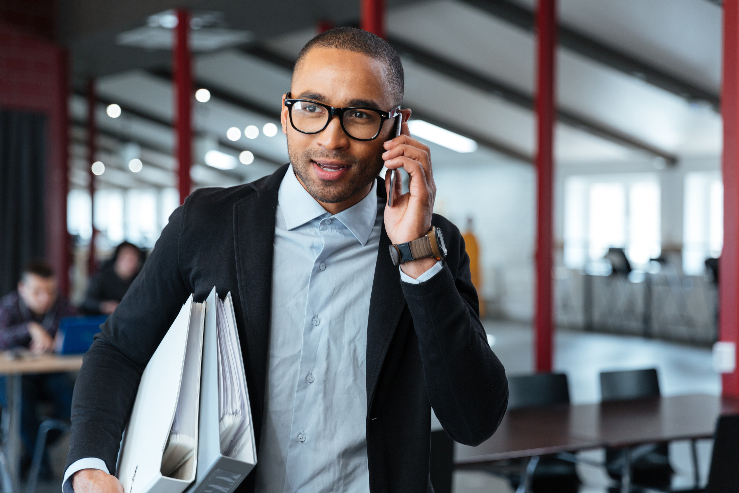 bisnessman carrying folders and talking on the phone